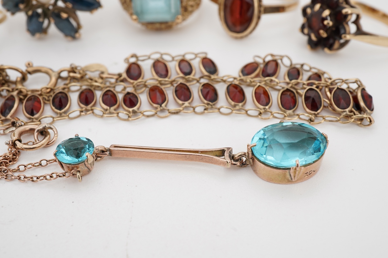 A group of jewels, comprising: two garnet cluster rings; a garnet bracelet; and a blue topaz ring, each mounted in 9ct gold, ring sizes H-M1/2, combined gross weight 13 grams; together with a marquise-shaped sapphire and
